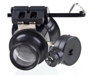 Oogloupe – ook wel juweliersloupe genoemd – op een brilmontuur met extra LED-verlichting. De loupe kan best 15 of 20 x vergroten.